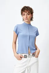 Top blanco de tejido de punto acanalado, con cuello alto, mangas cortas y abertura central en el ruedo.