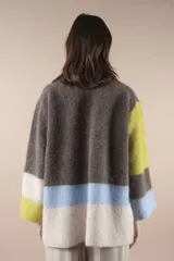 Sweater de lana multicolor con cuello redondo y mangas largas. Diseño con bloques de color en marrón, amarillo, celeste y blanco.