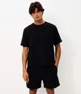 Bermuda masculina de moletón, con cintura elástica y cordón ajustable, bolsillos laterales funcionales y diseño liso con bordado sutil.