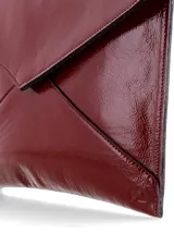 Sobre de fiesta tipo sobre, confeccionado en cuero charol color bordó, con solapa en forma de sobre y correa de mano removible.