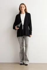Ruana negra de tejido de punto, con mangas largas y cordón ajustable en la cintura.