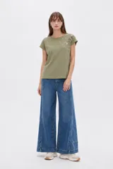 Remera verde militar de algodón, de corte holgado, con cuello redondo a la base y detalle de bordado floral en el hombro y pecho.