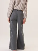 Pantalón de jean gris oscuro con corte recto y tiro medio. Presenta costuras a contra tono, bolsillos laterales y cierre frontal con botón.