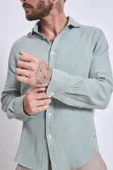 Camisa celeste de manga larga con textura arrugada.