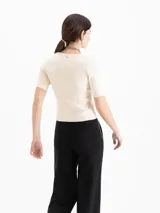 Top de punto morley color negro, con silueta ajustada al cuerpo, mangas cortas y escote redondo pronunciado.