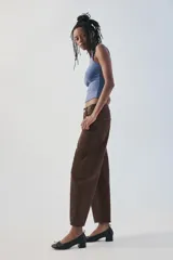 Jeans de tiro medio color marrón con diseño de volumen crop, silueta holgada en las piernas y cinco bolsillos tradicionales. Cierre frontal con cremallera y botón metálico.