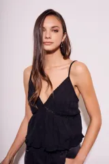 Blusa negra de algodón con breteles finos, escote en V con detalle de encaje y diseño con volados en el ruedo.