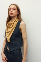 Pañuelo de cuello de tela suave y ligera en color beige, con diseño liso y terminaciones simples.