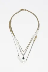 Collar multicapa de estilo vintage con cadenas combinadas en tonos dorados y plateados. Presenta aplicaciones de cuentas transparentes tipo perla, un dije de piedra oscura y un cierre decorativo tipo imperdible.