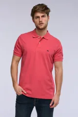 Remera polo de piqué color salmón, con cuello tejido en rib, cierre frontal de dos botones y pequeño bordado contrastante en el pecho.