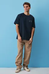 Remera de algodón color azul marino, de corte holgado y manga corta, con un pequeño estampado gráfico en el pecho con la leyenda "Create Art".
