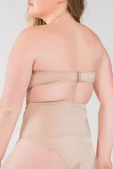 Soutien sin breteles color piel, moldeado en lycra, sin aro, con ganchos regulables en la espalda y ballenas en los costados.