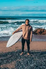 Hoodie marrón oversize con capucha y estampado en la espalda con los textos "Glassy Waves" y "Good Vibes" junto con una flor de hibisco.