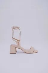 Sandalias negras de cuero con tacón cuadrado y tiras finas para atar al tobillo.