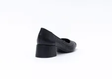 Zapato de cuero color nude, con taco cuadrado y punta fina. Presenta perforaciones decorativas en el empeine.