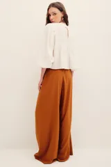 Pantalón ancho negro de tiro medio, con bolsillos laterales y pinzas frontales.