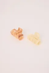 Pack de dos pinzas para el pelo tipo garra, en tonos rosados. Una pinza es de color rosa claro/crema con veteado marrón claro, y la otra es de color rosa pálido/amarillento con veteado sutil.