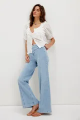 Pantalón de jean de tiro alto, color celeste claro, con corte ancho y costura central vertical que recorre la pierna.