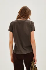 Remera de algodón color marrón oscuro con cuello redondo y manga corta. Estampado frontal con flores blancas y detalles en lentejuelas doradas, hojas verdes y texto en azul oscuro que dice "TRÈS CHIC".