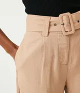 Short de lino y viscosa color tostado, de tiro alto con pliegues delanteros, bolsillos laterales y cinturón incorporado con hebilla cuadrada forrada.