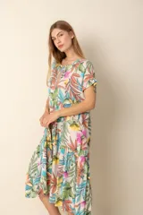 Vestido largo estampado con flores en tonos violeta, naranja, verde y azul sobre un fondo beige claro. Tiene cuello en V y mangas cortas.