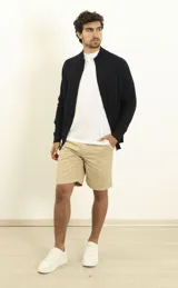 Bermuda de gabardina azul oscuro, corte recto, con bolsillos laterales y traseros.