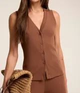 Blusa chaleco Marfinno confeccionada en ribana de viscosa, de color negro, con textura acanalada, escote en V, sin mangas y cierre frontal con botones.