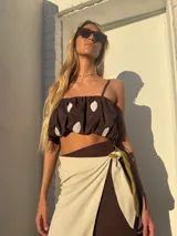 Falda envolvente tipo pareo de largo midi, confeccionada en lino. Presenta un estampado con bloques de color en tonos chocolate, pistacho y crudo.