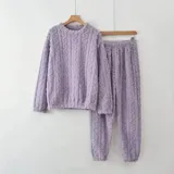 Conjunto de pijama de dos piezas confeccionado en plush suave con textura de ochos. Incluye una remera de manga larga con cuello redondo y un pantalón de corte recto con cintura elástica.