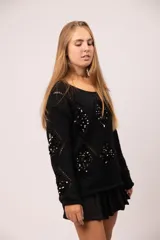 Buzo negro de tejido de punto con diseño calado de rombos y apliques de lentejuelas negras en el frente y las mangas.