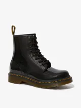 Botas Dr. Martens modelo 1460, de charol negro brillante, con cordones negros, costuras amarillas en la suela y tira trasera con logo AirWair.