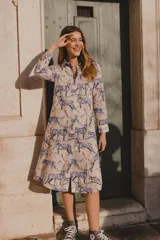 Túnica de lino y algodón color beige con estampado de leopardos y estrellas en azul. Tiene cuello solapa y largo por debajo de la rodilla.