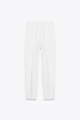 Pantalón tobillero de tiro alto con estampado de cuadros pequeños en tonos beige y negro. Presenta costuras marcadas en el delantero y la espalda, bolsillos laterales de vivo y cierre frontal con cremallera, botón interior y gancho metálico.