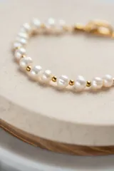 Pulsera dorada de acero quirúrgico con baño de oro 18k, decorada con perlas de agua dulce.