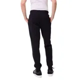 Pantalon tipo jogger de la marca Rusty, color negro, con cintura elástica ajustable mediante cordón, bolsillos laterales y puños elásticos en los tobillos. Presenta un pequeño logo bordado en la pierna izquierda.