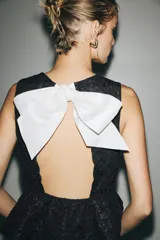 Top sin mangas negro de tejido jacquard con diseño texturizado, escote redondo y corte peplum acampanado.