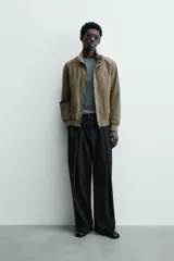 Cazadora azul marino de corte regular fit, confeccionada en tejido técnico repelente al agua. Presenta cuello subido, manga larga, bolsillos de vivo en cadera, bolsillo interior y acabados en rib en puños y bajo. Cierre frontal de cremallera oculta por solapa con botones a presión.