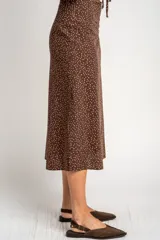 Falda midi de corte recto, color marrón con estampado de lunares pequeños en tono claro. Presenta un diseño de tiro alto y largo hasta la pantorrilla.