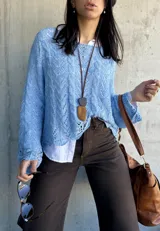 Sweater celeste de hilo con calados y mangas largas acampanadas.