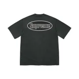 Remera Supreme de manga corta en color negro con efecto lavado, corte clásico y cuello redondo. Presenta un gran gráfico ovalado en la espalda con el logotipo de la marca en tipografía gótica dentro de un óvalo blanco.