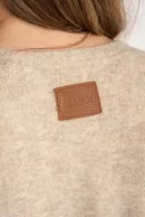 Cardigan abierto de punto con diseño de bloques de color en tonos beige, marrón y bordó. Presenta mangas largas, corte recto y bolsillos frontales aplicados.