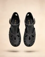 Sandalias de cuero negro con calados orgánicos y costuras en contraste color blanco, pulsera regulable con hebilla y taco bajo.