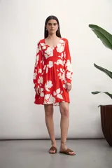 Vestido corto rojo con estampado de flores blancas, escote en V y mangas largas.