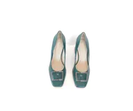 Zapato de cuero color verde, estilo stiletto con punta cuadrada y aplique metálico en el empeine. Posee un taco ancho de altura media con textura geométrica.