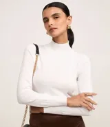 Blusa de manga larga color blanco, confeccionada en viscosa sostenible, con cuello alto y corte ajustado.