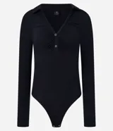 Body negro de rib, con cuello polo, escote en V, mangas largas y frunces en el busto. Cierre inferior con botones a presión.