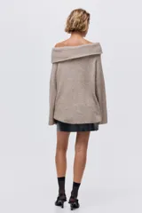Buzo de punto acanalado suave color beige, con escote off-the-shoulder y corte holgado.