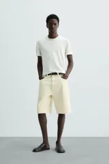 Camiseta relaxed fit de punto ligero color blanco hueso, con cuello redondo y manga corta. Acabados en rib.