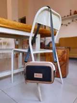 Bandolera rectangular combinada en color negro, beige y blanco, con correa larga regulable y bolsillo exterior con cierre.