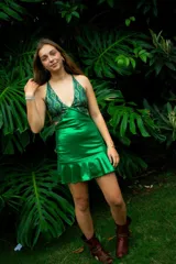 Vestido corto plateado con lentejuelas, escote en V y cut-outs laterales bajo el busto. Breteles finos que se cruzan en la espalda y atan atrás. Volado en el ruedo.